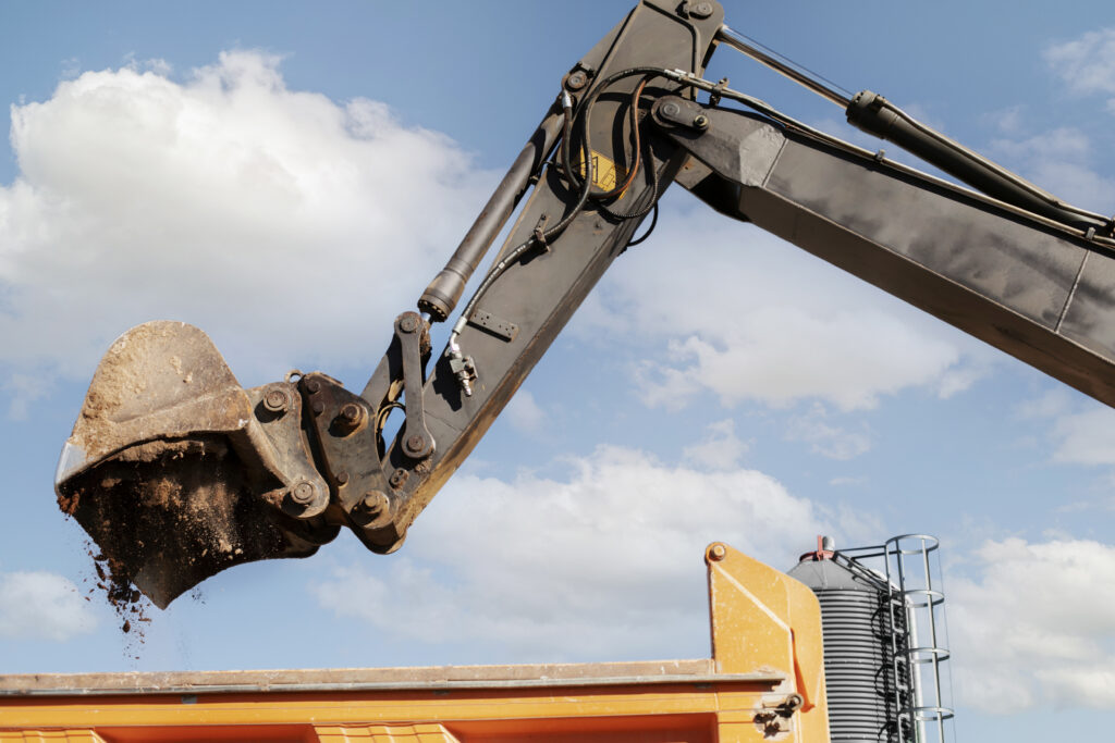An image of an excavator digging ground during a commercial demolition service.