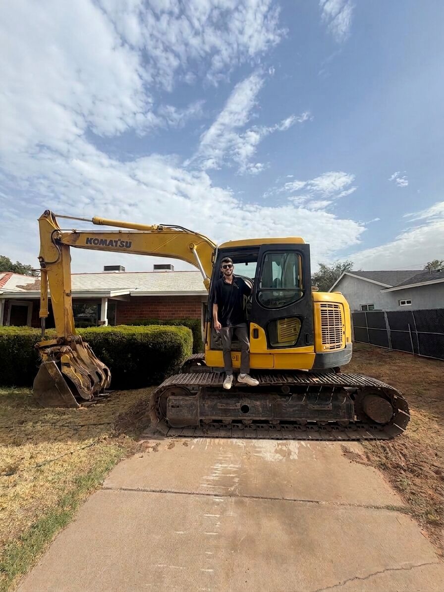 A Kogan LLC team member standing on a Komatsu excavator at a Phoenix, Arizona jobsite