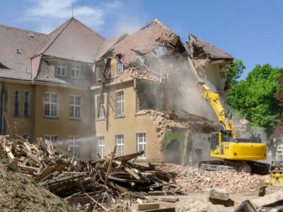 digger demolishing houses for reconstruction.